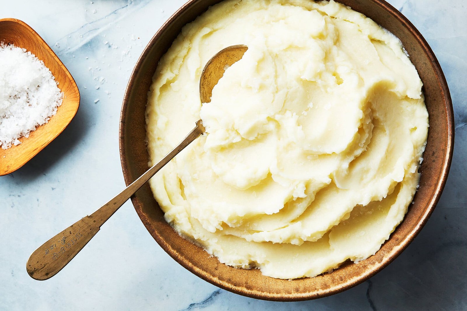 An overhead image of creamy mashed potatoes in a serving bowl.